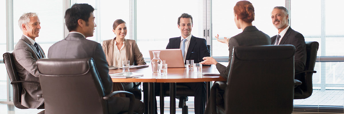 Business people sitting around a board room table